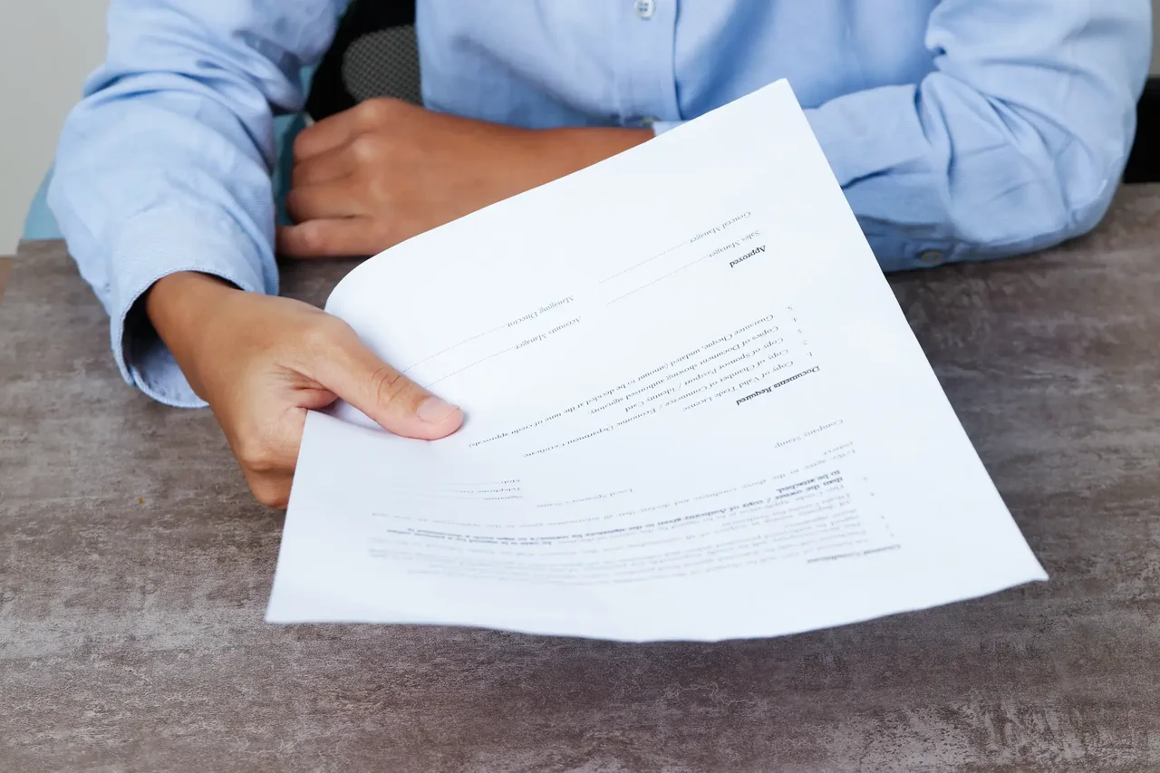 Business professional handing over a document — document translation services by Loop Translate