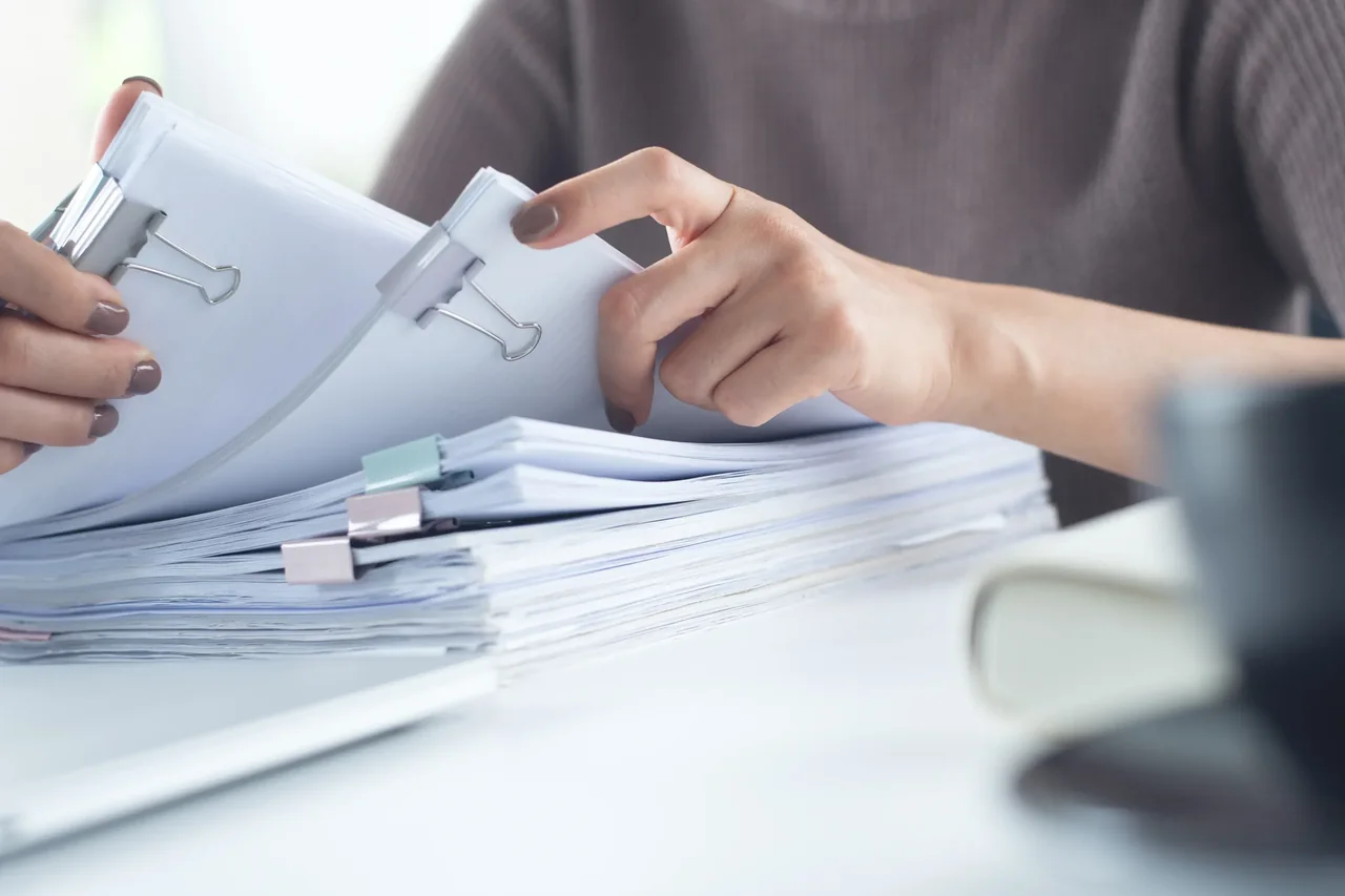 Loop Translate document translation services Professional sorting paper documents at a desk — document translation services by Loop Translate