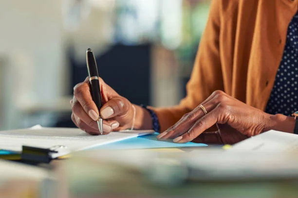 Loop Translate document translation services Professional writing notes while reviewing documents — document translation services by Loop Translate