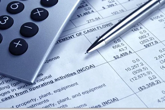 Financial statement beside a calculator and pen — document translation services by Loop Translate