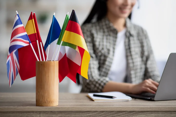International flags on a desk with a professional working behind them — document translation services by Loop Translate