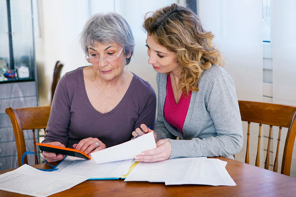 Loop Translate document translation services Two women reviewing paperwork together at a table — document translation services by Loop Translate